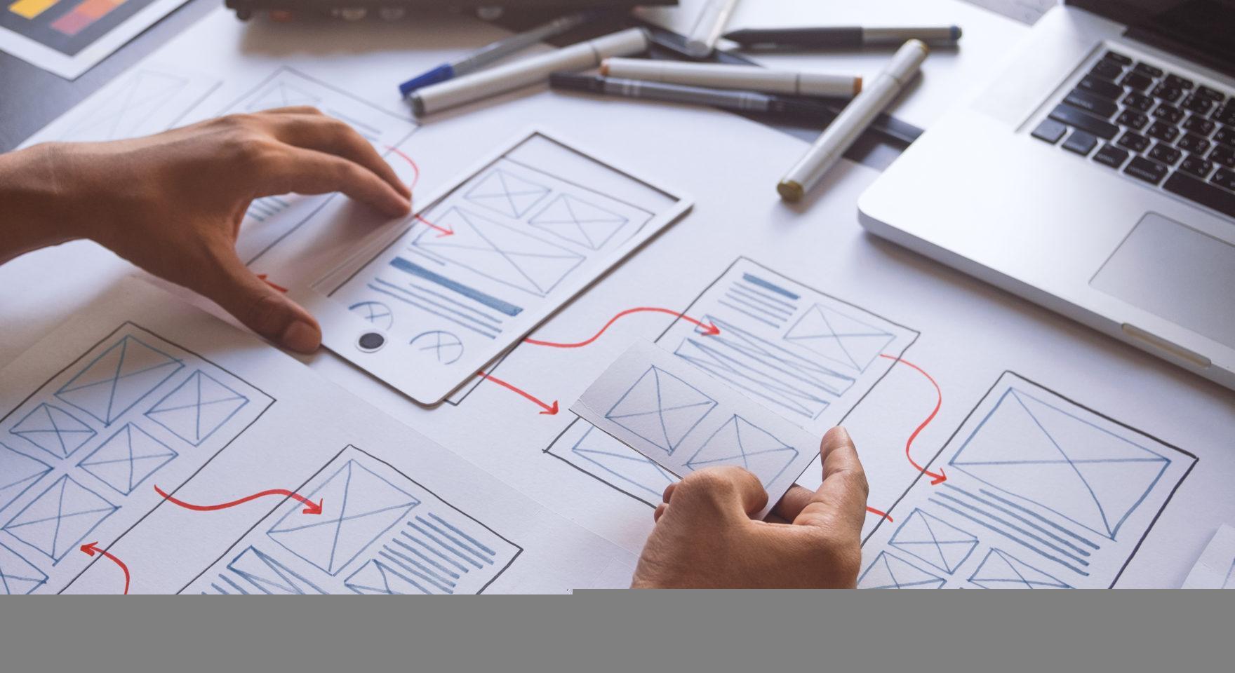 UX designer sketching wireframe and prototype on paper