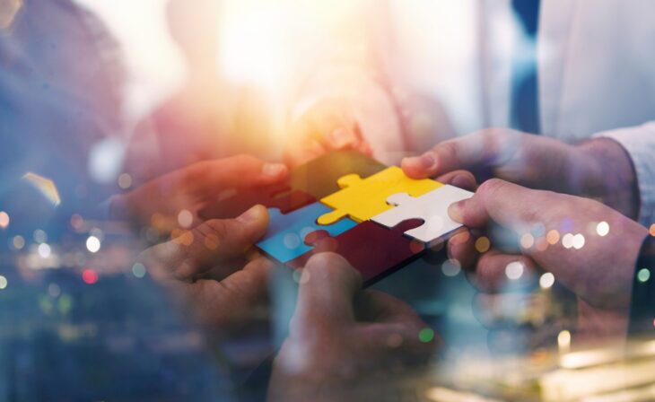 Business people connecting puzzle pieces symbolizing teamwork