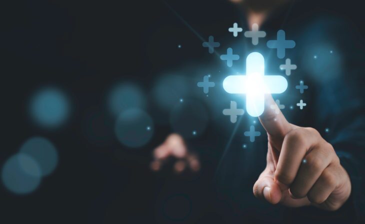 Businessman touching plus sign symbolizing profit growth
