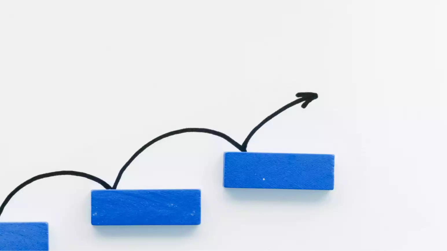 Blue blocks stepping upwards with a drawn arrow indicating progress on a white background.