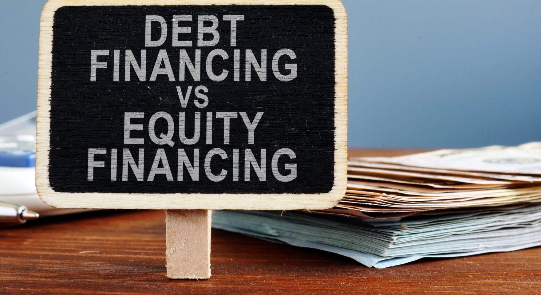 Debt financing vs equity financing concept. Calculator and cash.